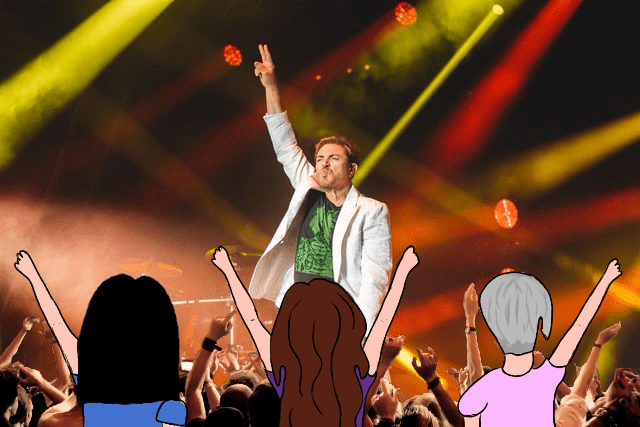 Simon Le Bon stands on stage and 3 cartoon women, One with Black hair, One with brown hair and one with silver hair, stand with there backs towards the image with arms up.