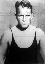 Black and white photograph of a Oliver with disheveled medium fair coloured hair  looking seriously just off the camera . He wears a black vest leotard.